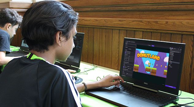 boy looking at laptop with donutland game on screen